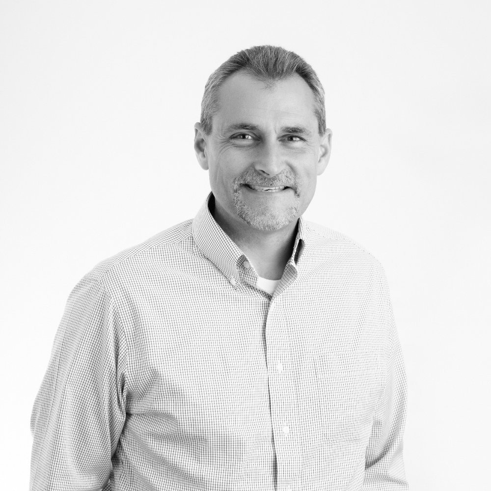 Black and white company headshot of middle age man