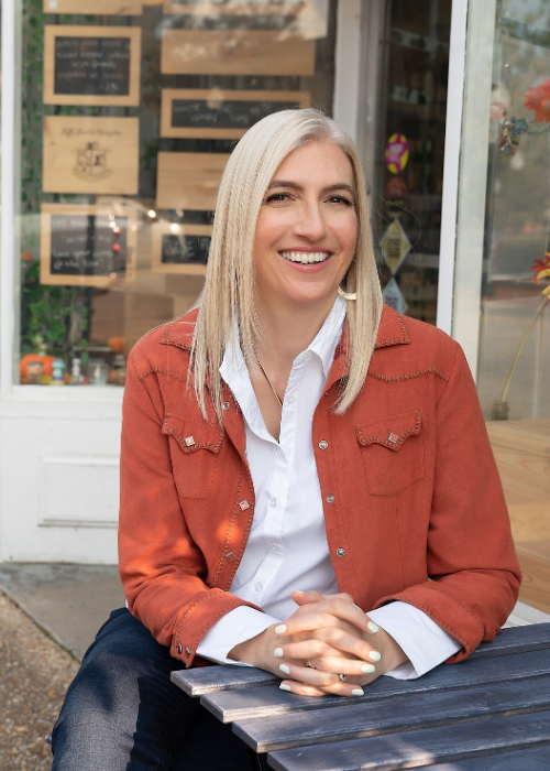 Woman for branding photograph in orange blazer outside cafe