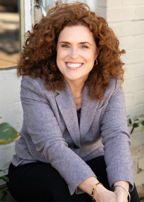 Woman with curly red hair, purple blazer, modern branding photography