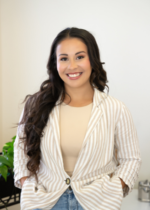 Professional branding photograph of woman in white blazer young in white office setting