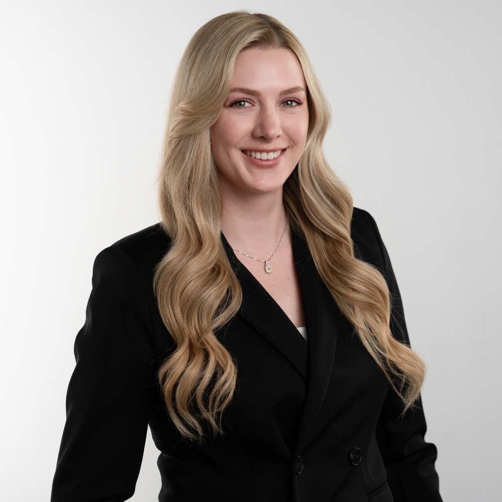 Young executive woman in black suite with long blonde hair company headshot on white background