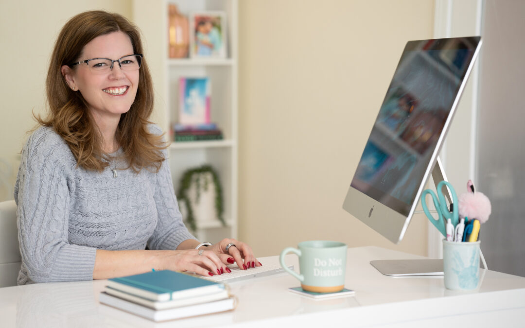 Executive headshots in Cary, NC. Professional woman at desk posing with computer.